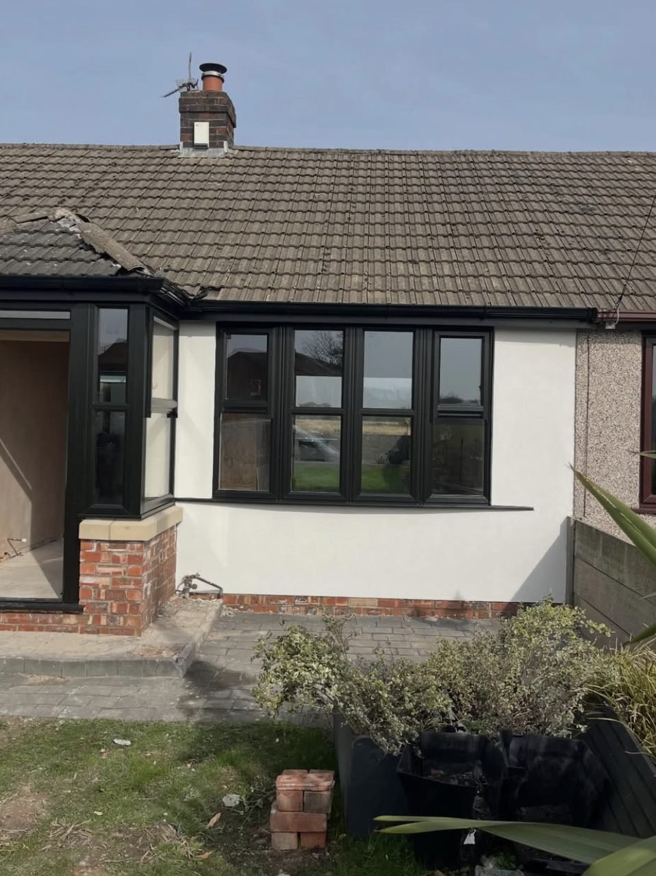 Bungalow with a smooth white rendered front beside a pebbledashed neighbour