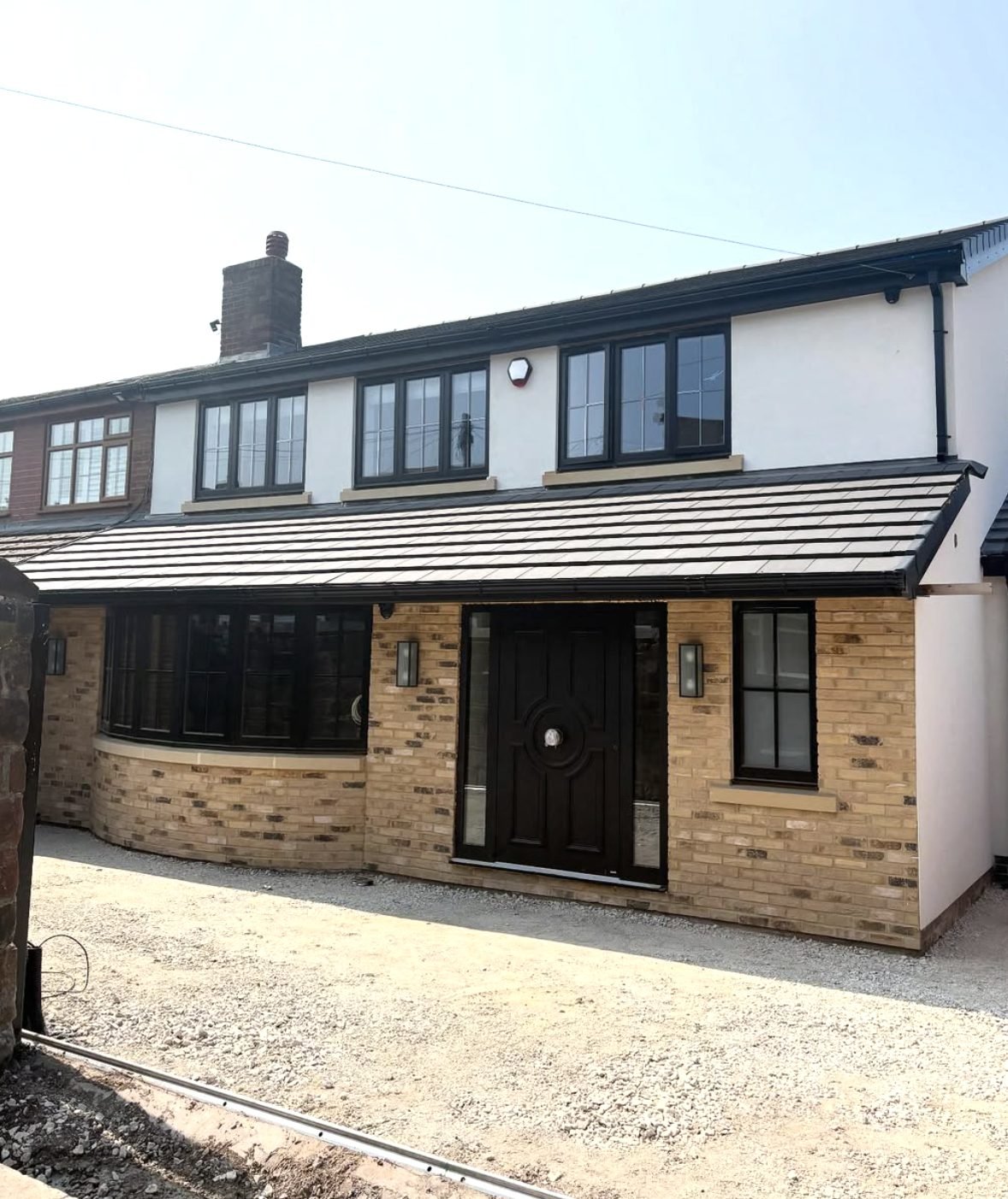 Semi-detached house with white render above a buff brick front extension